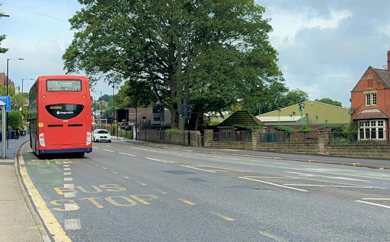 A double-decker bus passing by a bus stop in Sheffield.