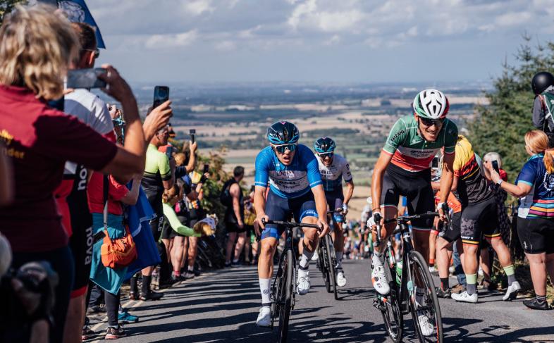 Action from a previous Tour of Britain, cyclists climbing a hill surrounded by crowds