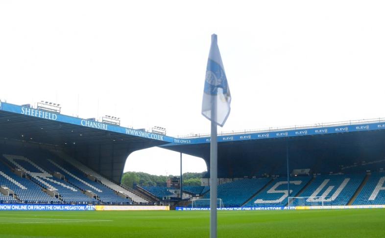 A view inside Hillsborough Stadium. View looking onto the football pitch with empty stands in the background and a flag in front of the camera.