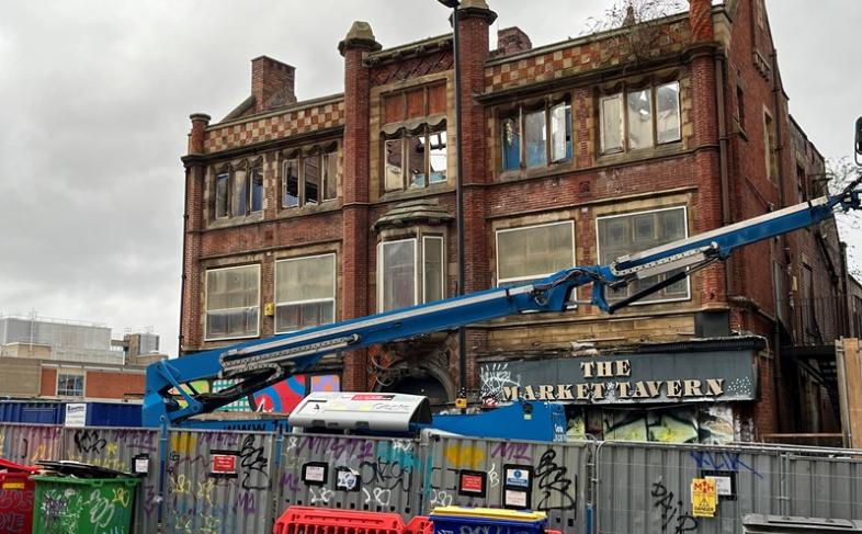 Image of the Market Tavern partly demolished. There is a blue crane in front of it