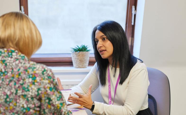 Noreen, Community Team Manager at IDAS Sheffield, speaking to another person at a desk