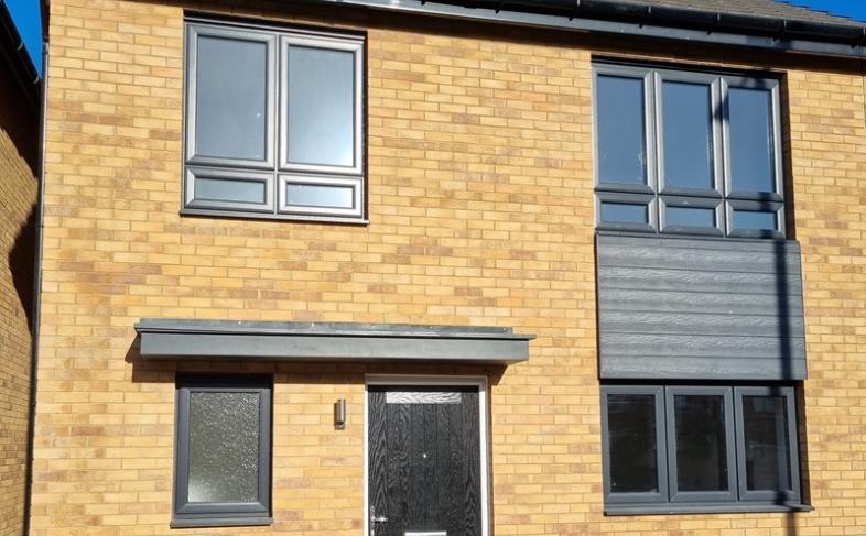 A brick house with black windows and doors 
