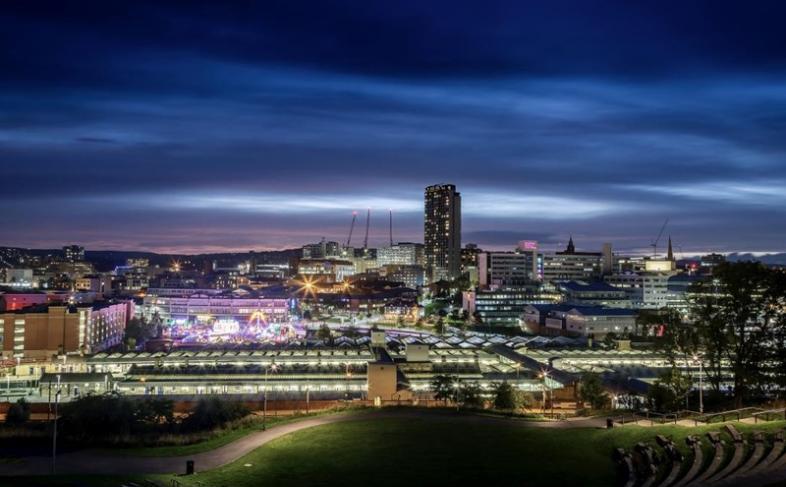 Sheffield city centre skyline in the evening with lights in the distance and an inky blue sky