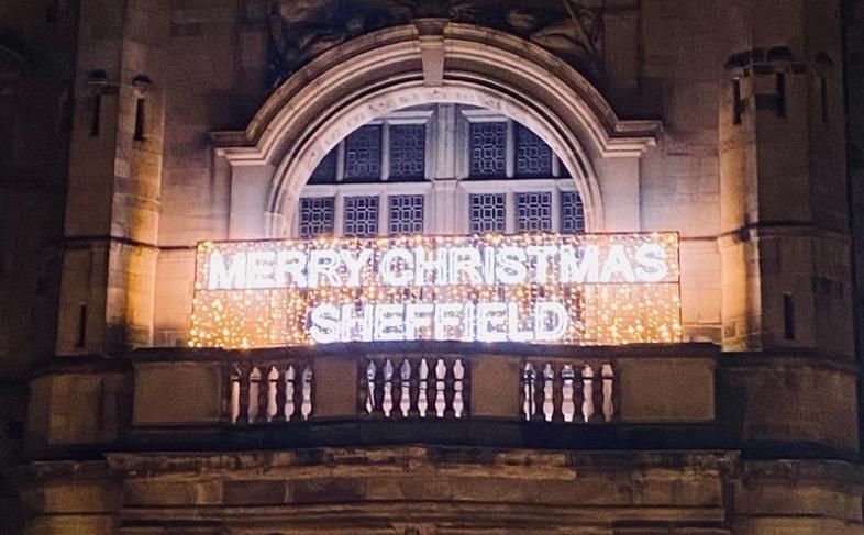 Town Hall entrance and balcony. Merry Christmas Sheffield is lit up on the balcony in white and gold lighting