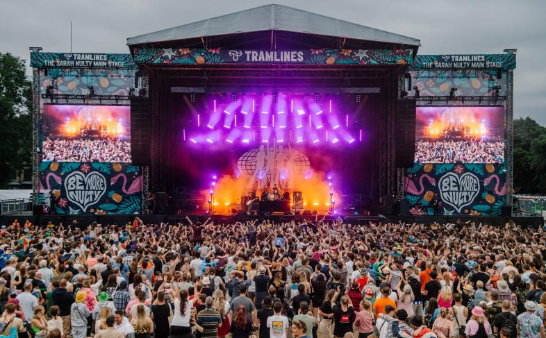 The main stage of Tramlines Festival as a band plays and a large crowd watches