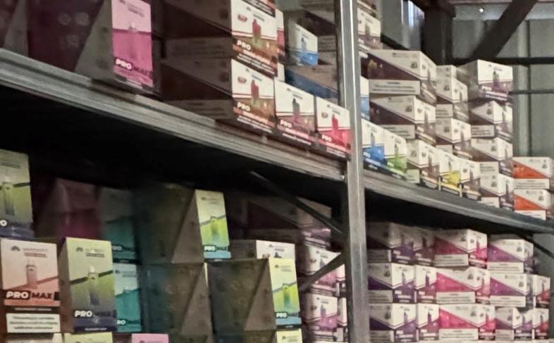 Illegal vapes stacked on metal shelving