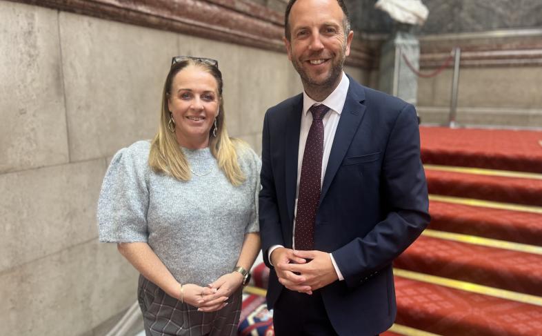 Cllr Dawn Dale and Cllr Ben Miskell stand on a staircase looking at the camera, behind them the red carpet can be seen going up the stairs.