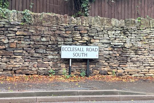 Ecclesall Road South road sign against a dry stone wall