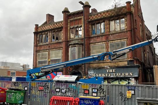 Market Tavern partly demolished. There is a blue crane in front of it.
