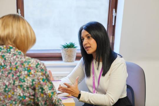 Noreen, Community Team Manager at IDAS Sheffield, speaking to another person at a desk