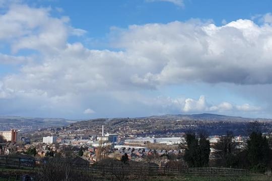 Sheffield skyline on a sunny, cloudy day, with rolling hills in the background