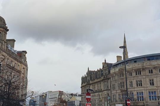 Top of Fargate showing tall buildings on either side. Its a dull day with clouds in the sky.