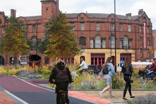 West Bar in Sheffield, with buildings in the background and people walk and cycling on paths with trees and grass around them
