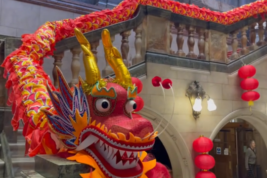A paper red Chinese dragon decoration on a grand staircase 
