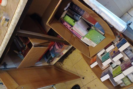 Image shows several boxes spilling out of a kitchen unit, each box contains illegal tobacco and vapes