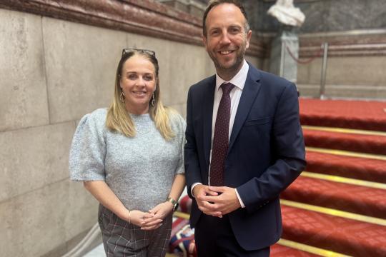 Cllr Dawn Dale and Cllr Ben Miskell stand on a staircase looking at the camera, behind them the red carpet can be seen going up the stairs.