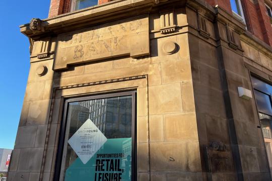 An image of the outside of a building with the brickwork showing the old 'Midland Bank' sign on it