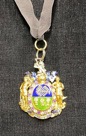 Lord Mayor’s Badge, made of gold, in the centre is the Sheffield City Arms in an enamel and diamond setting, surrounded by a border of amethysts and white topaz, surmounted by a visor and the lion rampant from the crest of the Duke of Norfolk. The city motto and coat of arms are included.